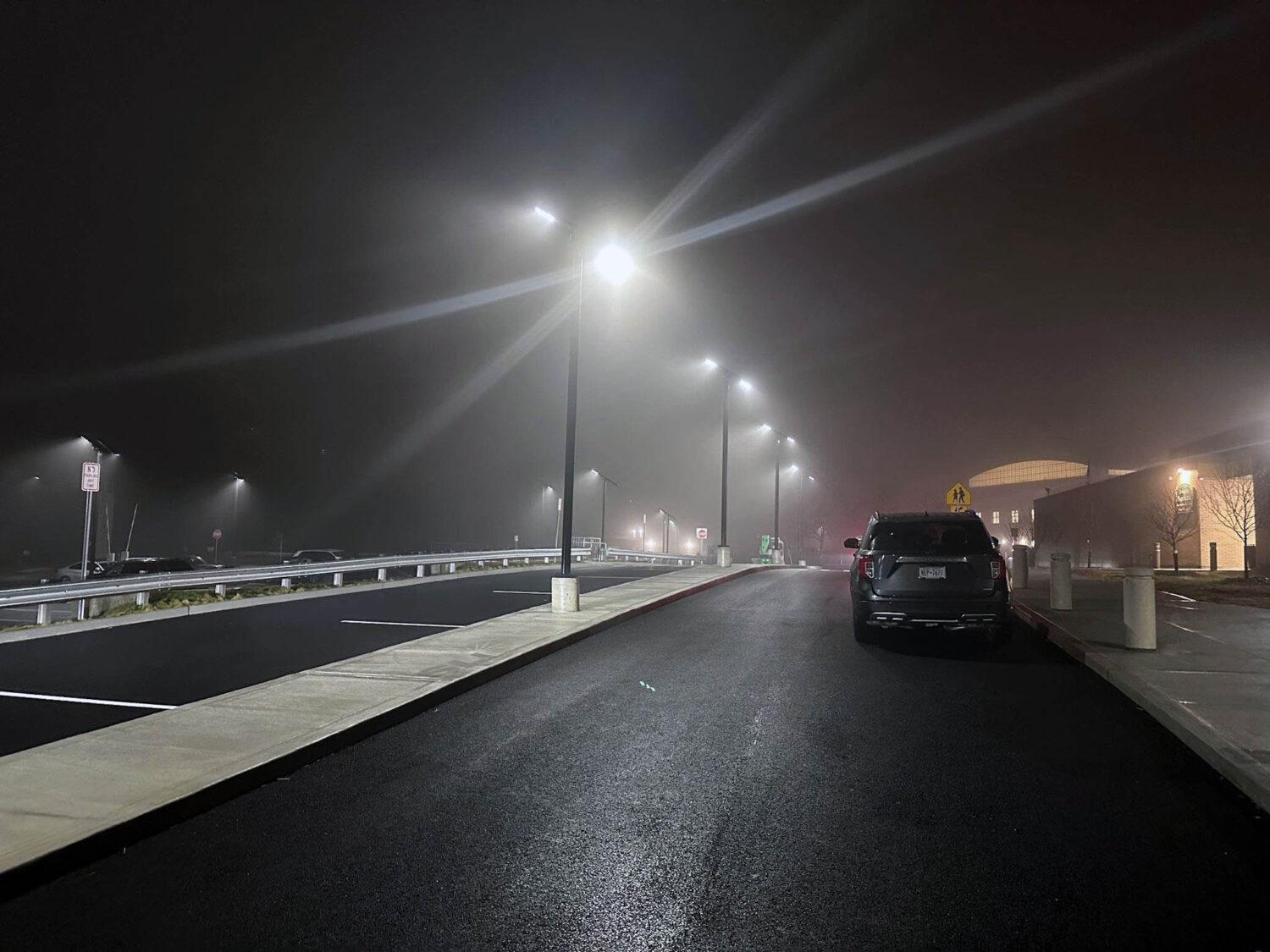 Solar parking lot lights illuminating a school parking area at night in New York.